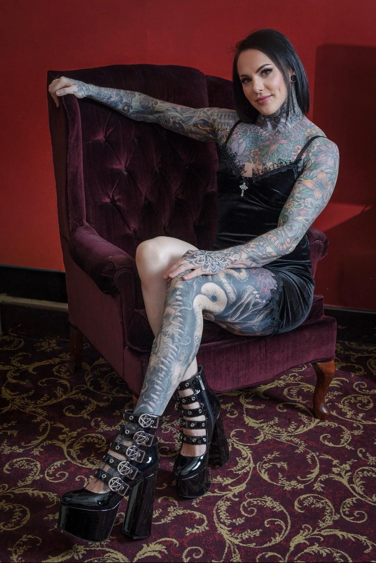 Ali Morgan in black boots on a velvet chair